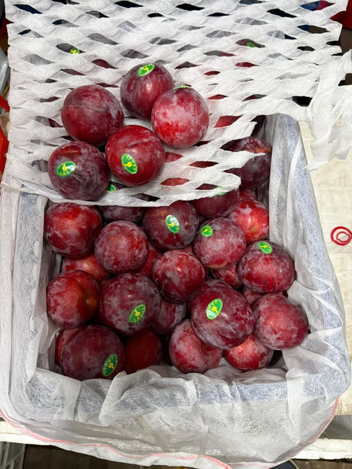 Fresh red plums in box