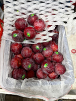 Fresh red plums close up in box